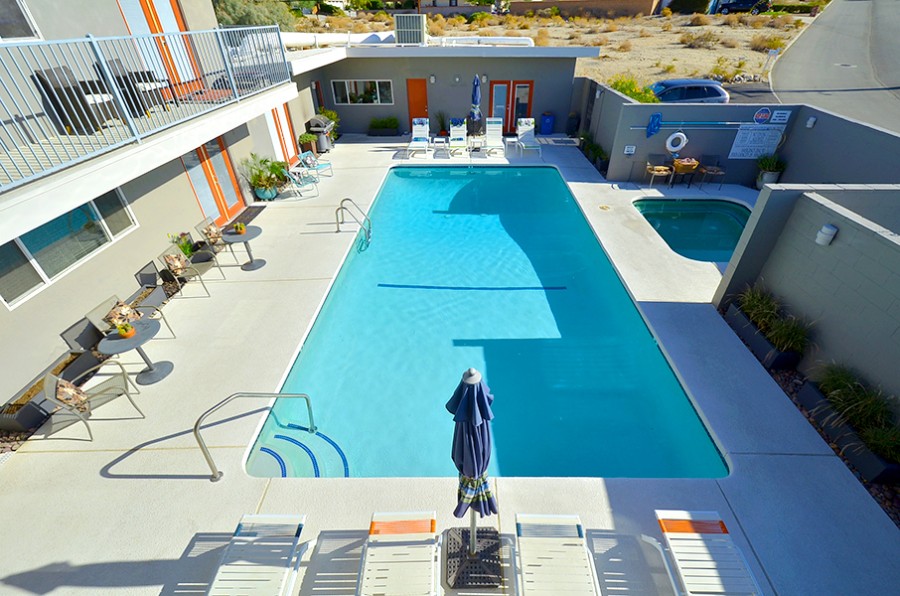 Swimming pool and surrounding guest rooms on a sunny day