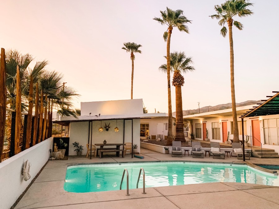 Swimming pool and palm trees at sunset near Joshua Tree National Park in Calfiornia