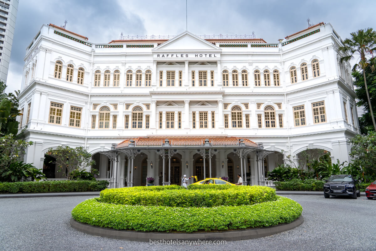 Raffles Hotel in Singapore on a cloudy day with roundabout entrance area