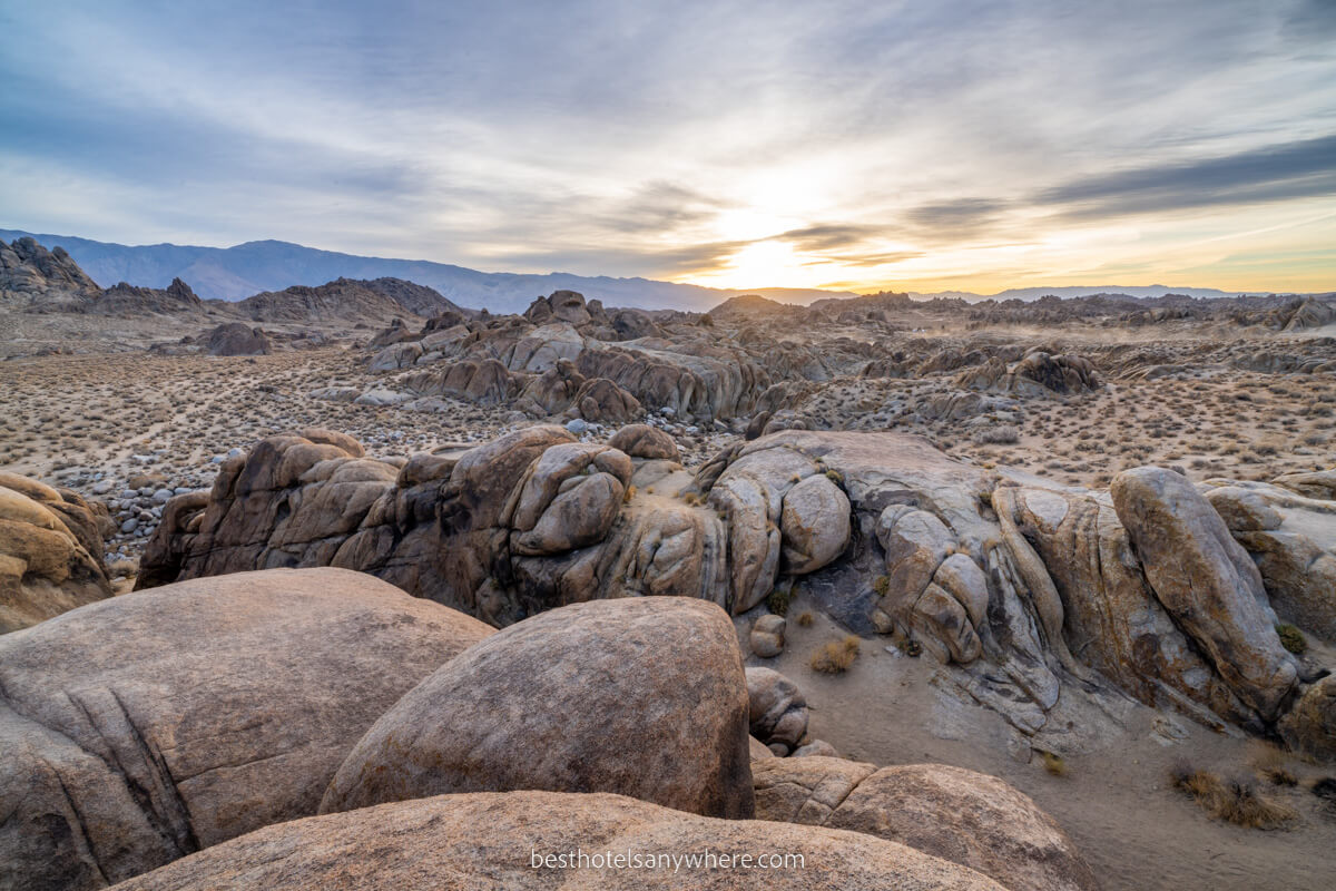 Alabama Hills at sunrise with soft yellow light pouring over rocky landscape and smooth rock formations