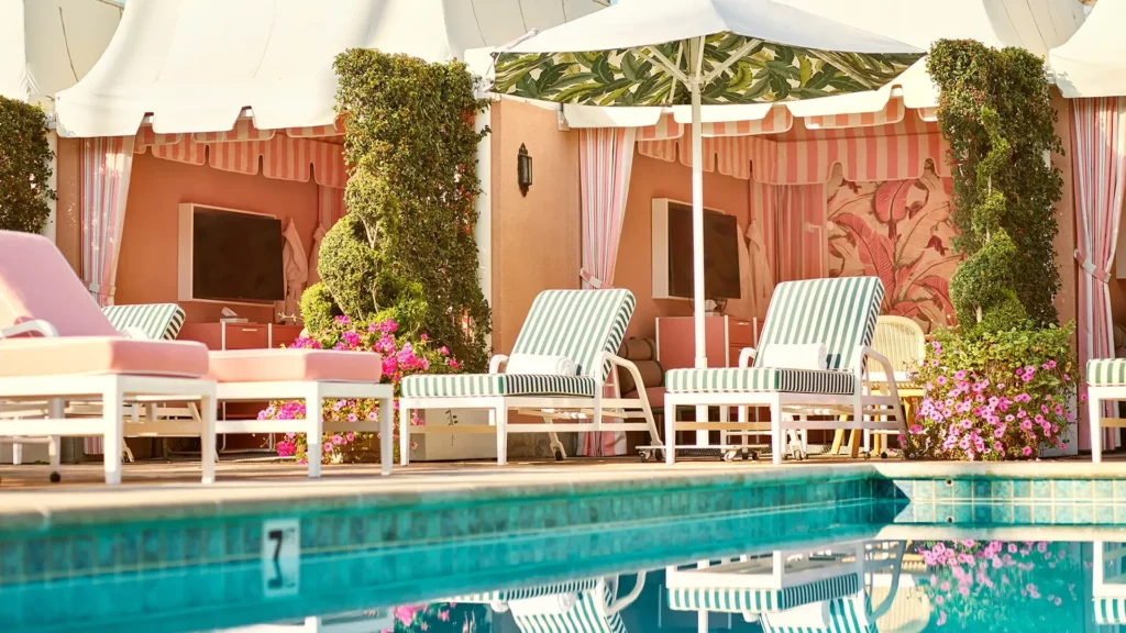 Swimming pool and sun beds with pink decor at The Beverly Hills Hotel one of the very best hotels in Los Angeles