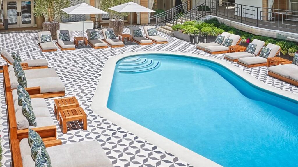 Large swimming pool with tiles and sun beds at a hotel in Los Angeles California