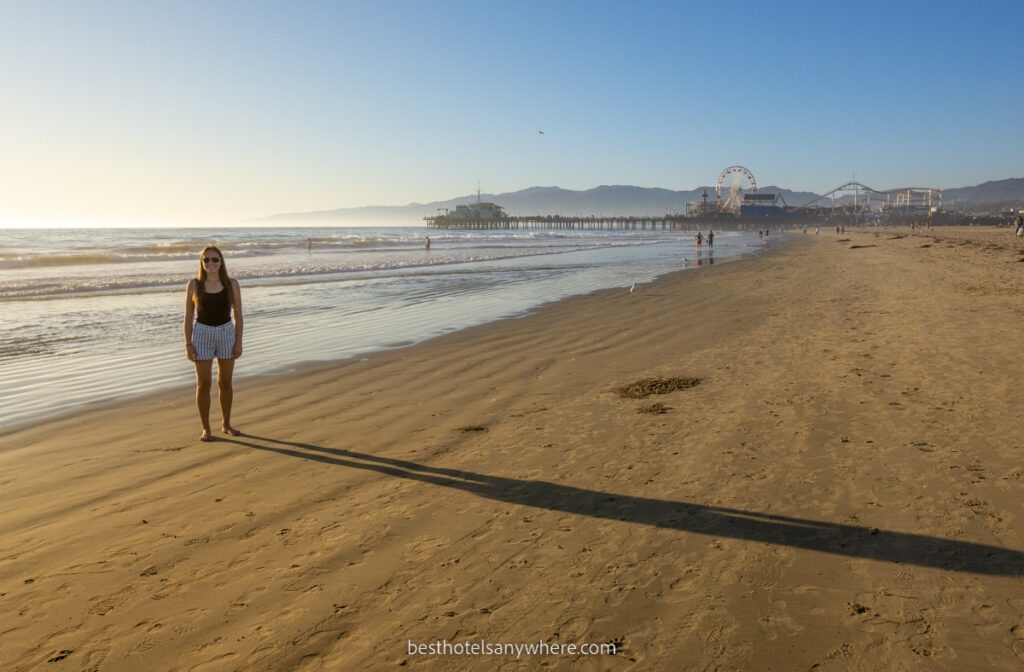 Woman on Santa Monica beach at sunset with Pier in background