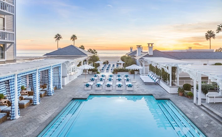 Stunning view of a swimming pool with lounging area either side leading to the beach and ocean Shutters on the beach one of the best hotels in Los Angeles Santa Monica