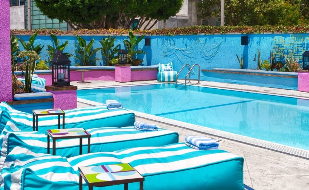 Colorful sun beds and table bright blue next to swimming pool