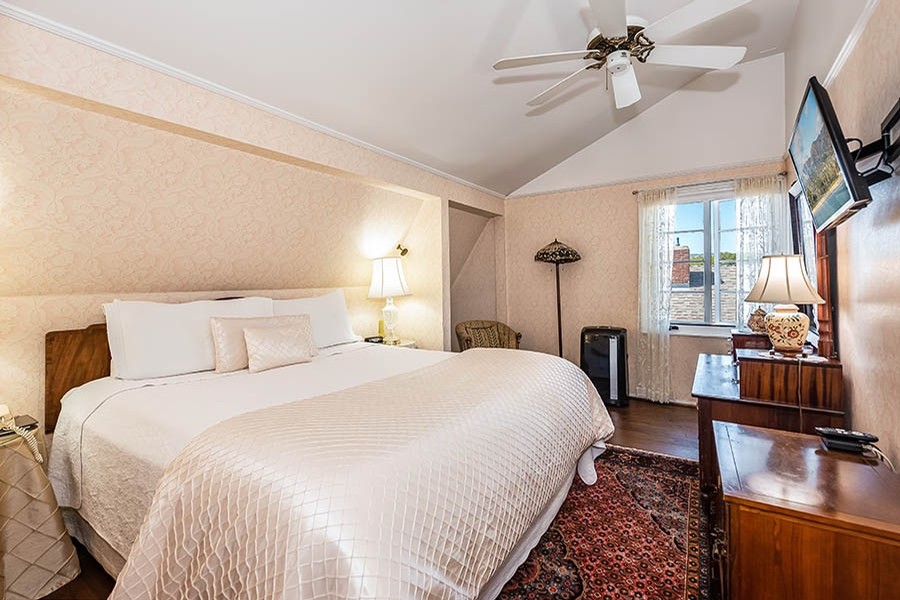 Hotel guest suite bedroom big bed with cream covers Bath Street Inn Santa Barbara