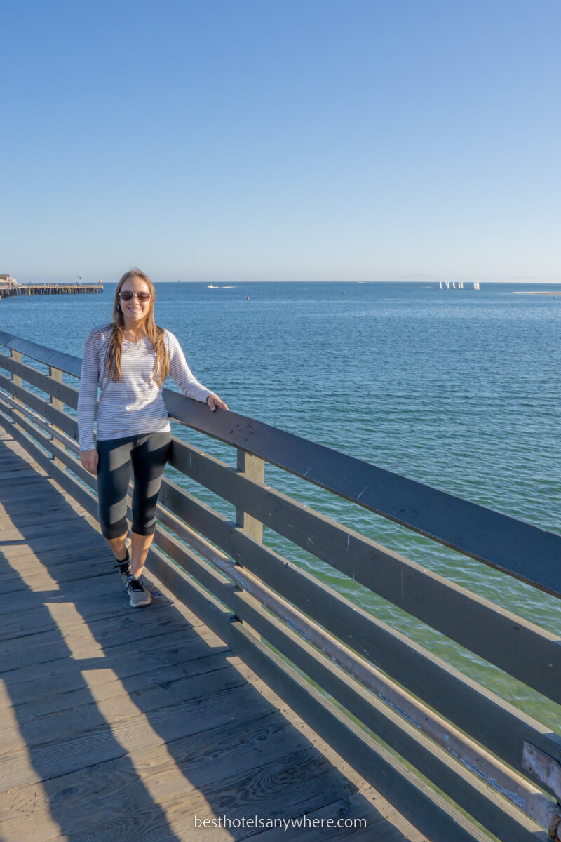 Woman standing on pier with turquoise water