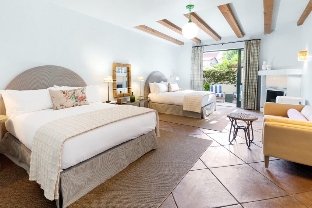 Guest room at Palihouse Santa Barbara plush suite with two double beds tiled floor and beams on roof very expensive downtown hotel option