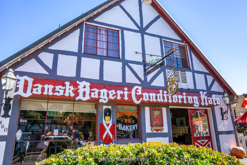 Typical shops and Danish building facades with red banners and flags near the best hotels in Solvang CA