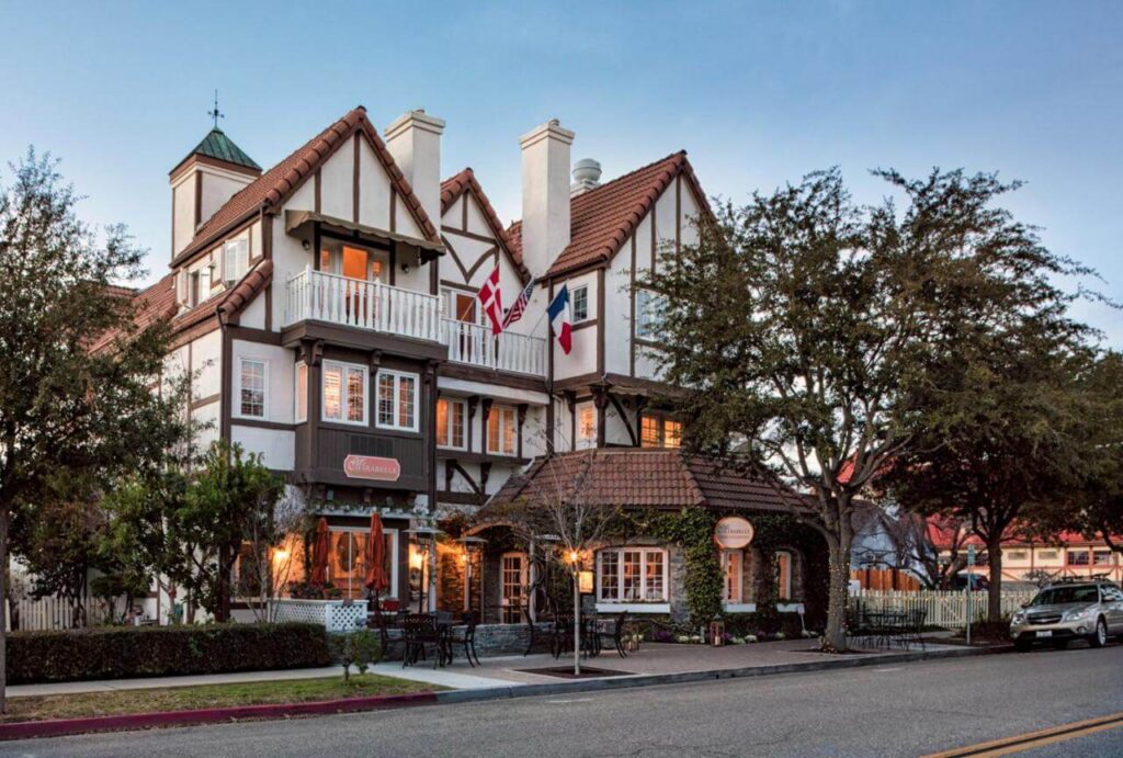 MIrabelle Inn one of the best hotels in Solvang CA from the outside with road leading to tall Danish house