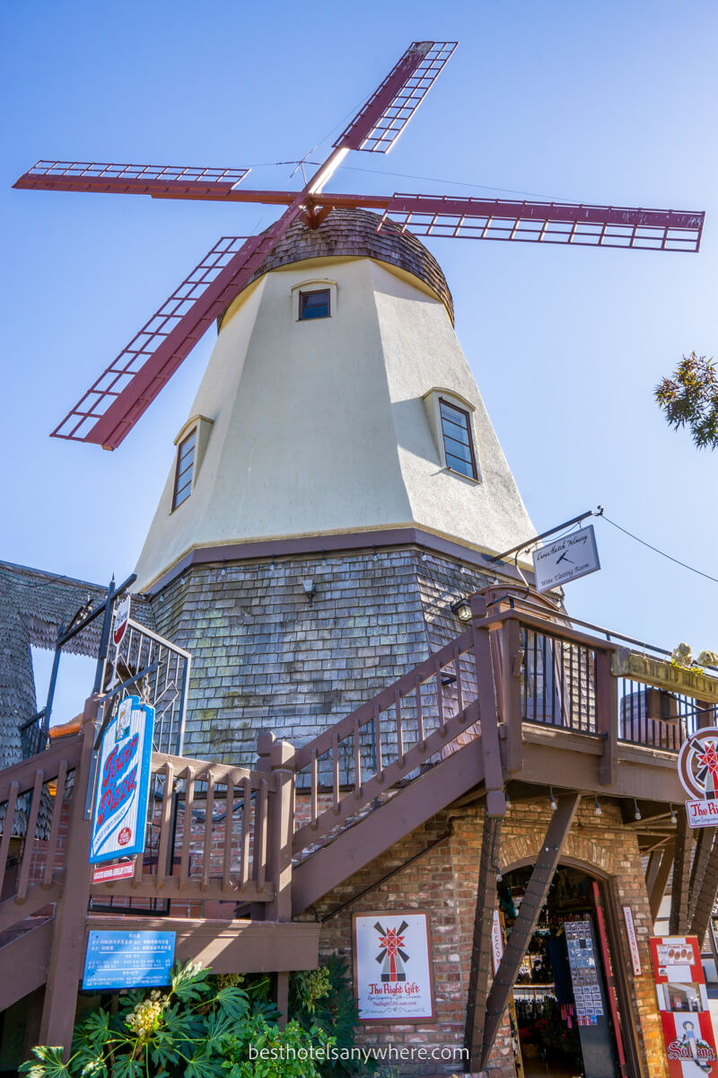 Windmill and red blades in the town of Solvang California with shops below