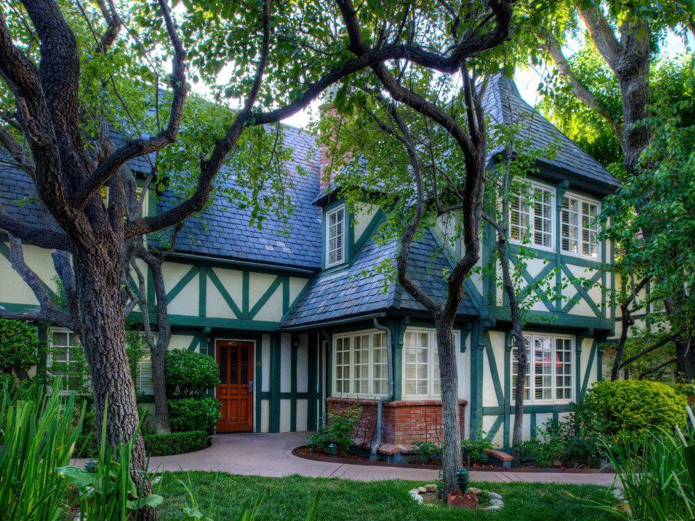 Lovely green garden setting with trees and a Danish style building Wine Valley Inn one of the popular Solvang hotels