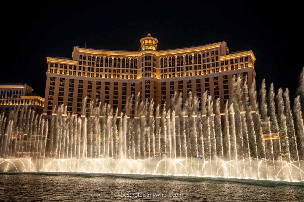 Fountain show at Bellagio one of the most luxurious Las Vegas hotels on the famous strip glowing yellow against dark sky