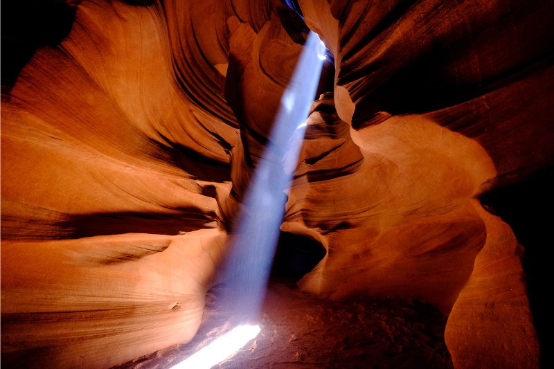 Light beaming into Antelope Canyon slot canyon lighting up the cave like sandstone formations