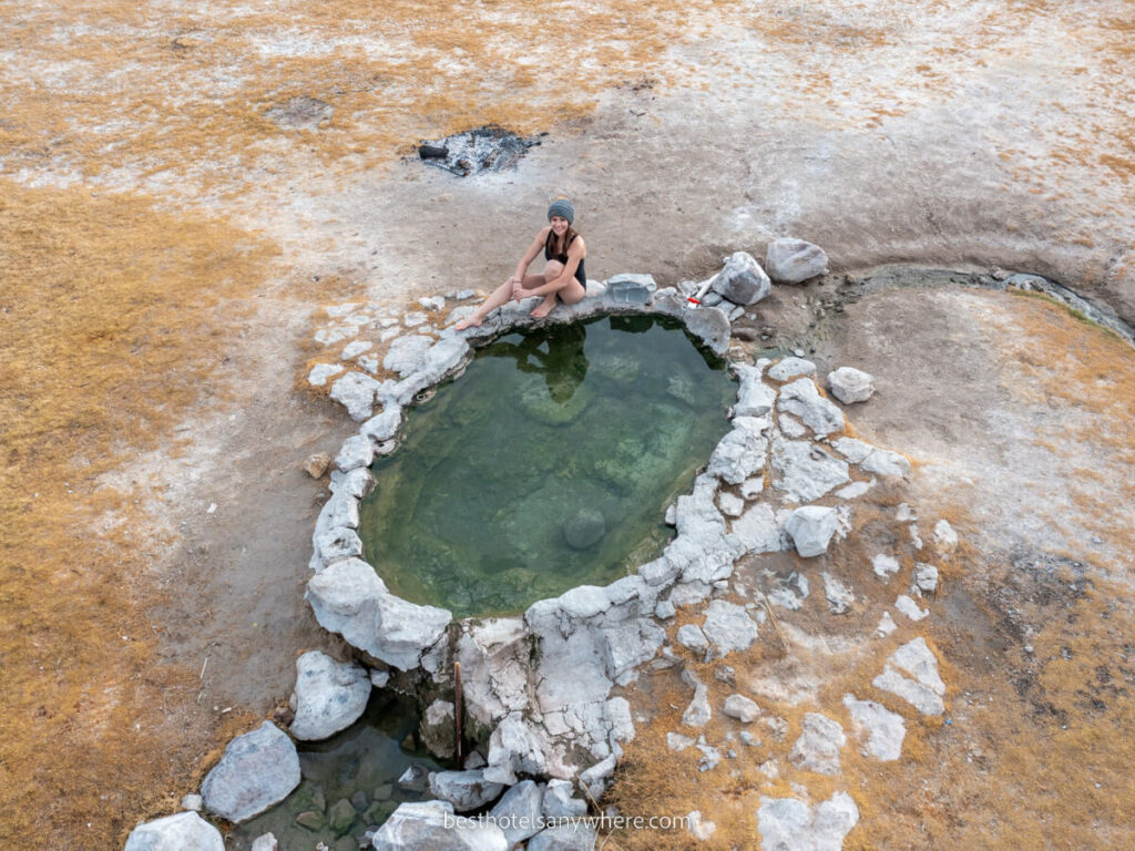 Woman sat on the edge of a natural hot spring pool photo taken from above near Mammoth Lakes CA