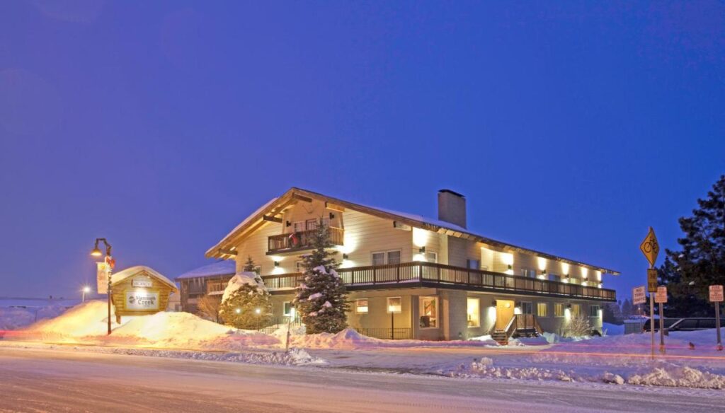 Building lit up at night with snow on ground and deep blue sky not long after twilight hotel in Mammoth Lakes