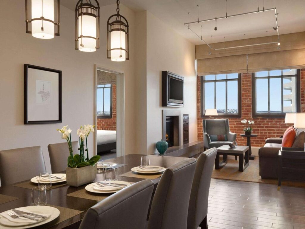Apartment interior exposed brick open plan living and dining with plenty of light Fairmont Heritage Place Fisherman's Wharf hotel in San Francisco