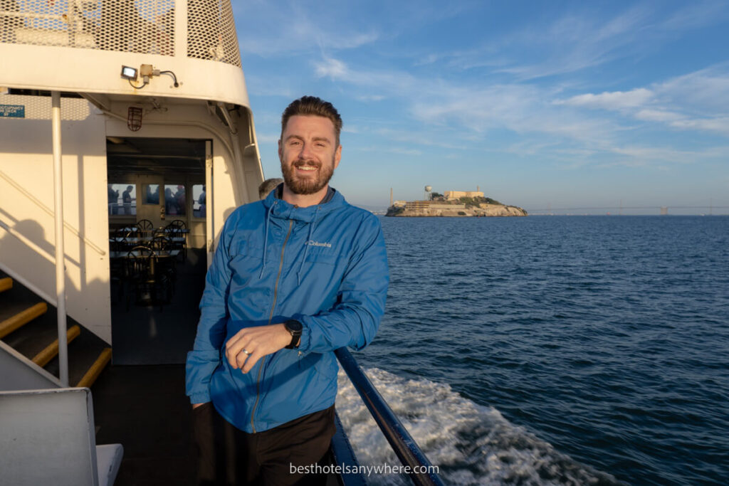 Mark from Best Hotels Anywhere on a sunset cruise in San Francisco Bay with Alcatraz Island in distance