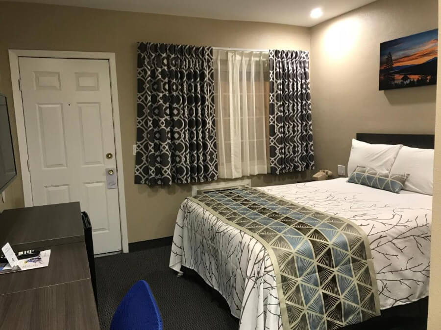Guest bedroom in a small room with bed door and curtains
