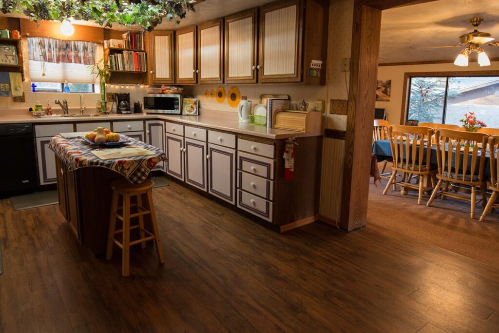 Kitchen and dining room in a quaint bed and breakfast with wooden floor and furniture