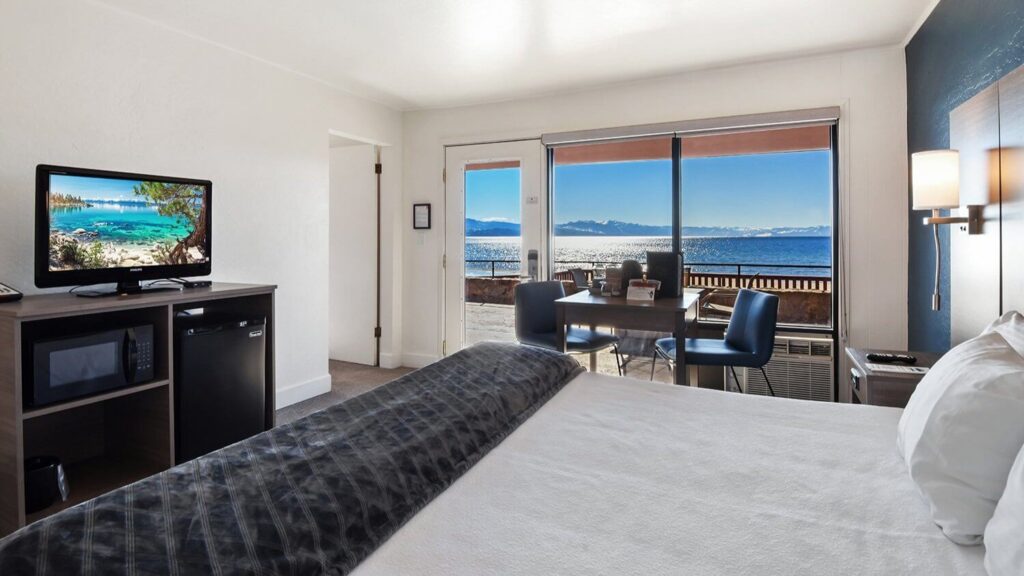 Guest bedroom with bed tv and balcony with view