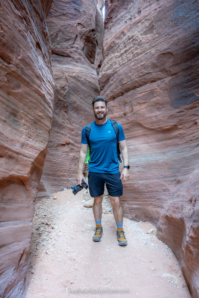 Hiker with camera in a narrow slot canyon called Buckskin Gulch on the Utah Arizona border