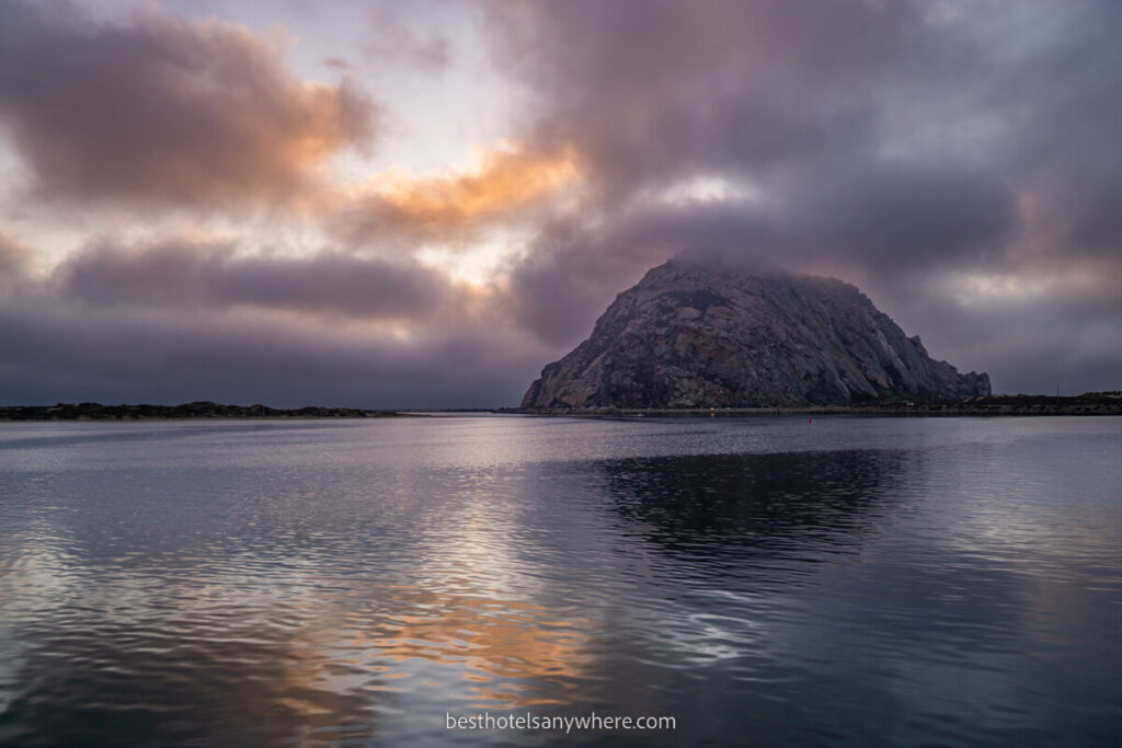 Colorful sunset with orange and pinks in the clouds behind Morro Bay CA