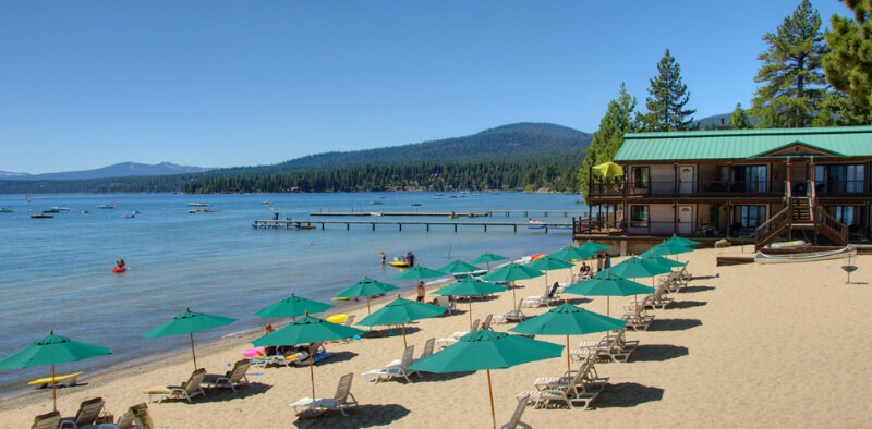 Beach with loungers and umbrellas in North Lake Tahoe with Mourelatos Resort hotel