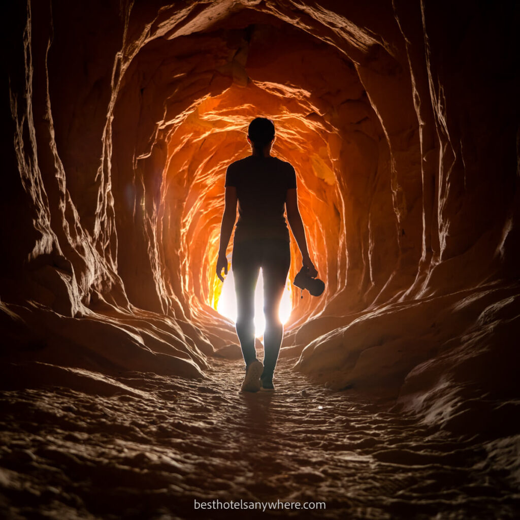 Woman silhouetted in a tunnel with orange light at the end