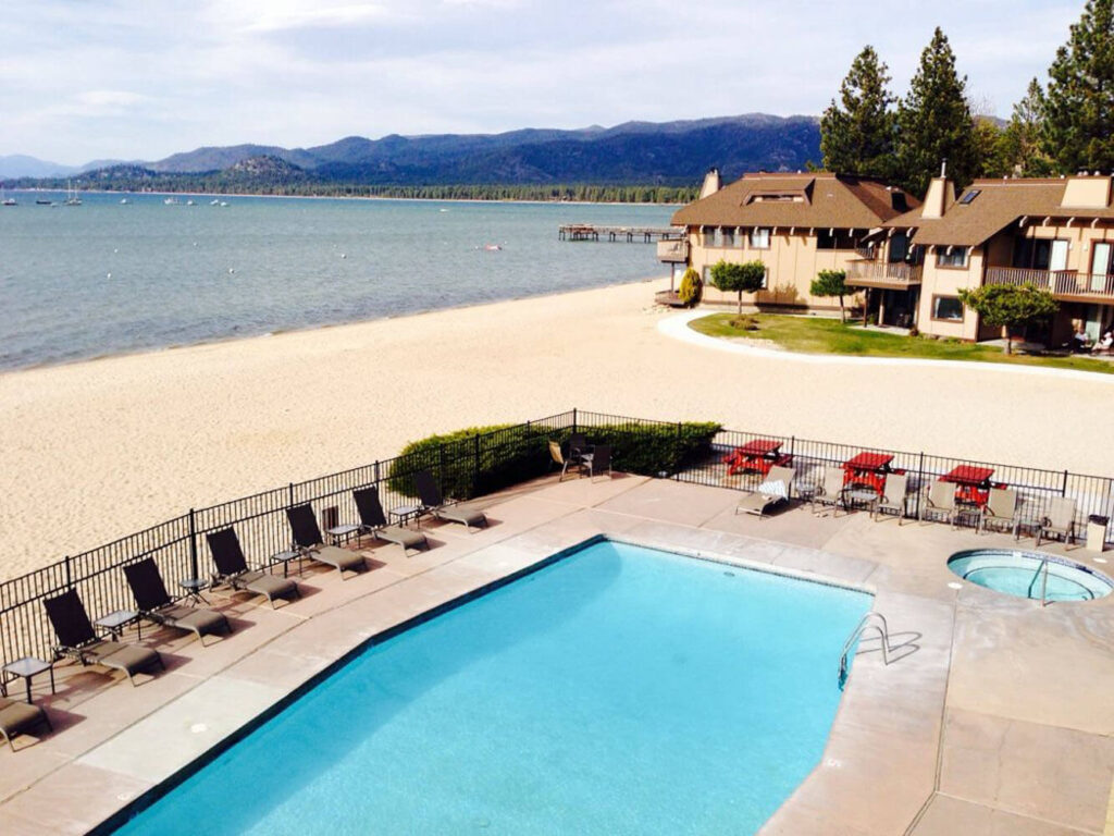 Swimming pool and hot tub leading onto sandy beach and Lake Tahoe
