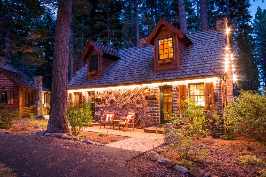 Small brick building in a forest at night with lights on outside stunning lodging in Tahoe City CA