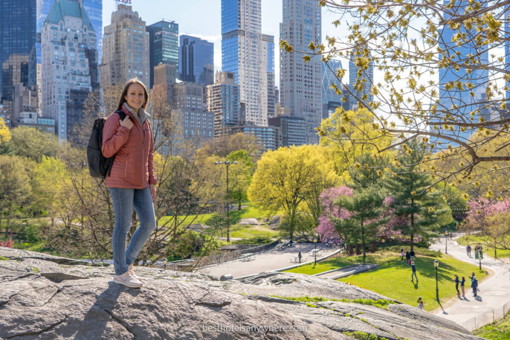 Tourist in New York enjoying a walk through green space with skyscrapers behind