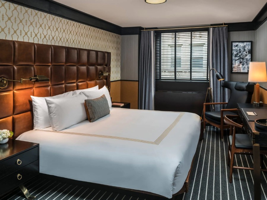 Luxurious guest bedroom at Gild Hall a Thompson Hotel in Downtown Manhattan with leather headboard and carpet in a compact room