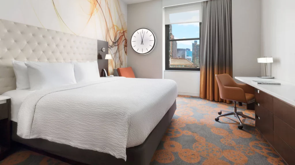 Guest bedroom at Residence Inn hotel in Lower Manhattan NYC with carpet bed and clock