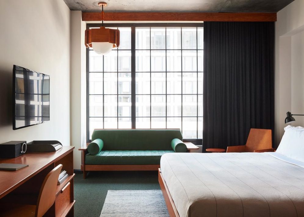 Unique guest bedroom at ACE Hotel New York with bed chair and huge windows