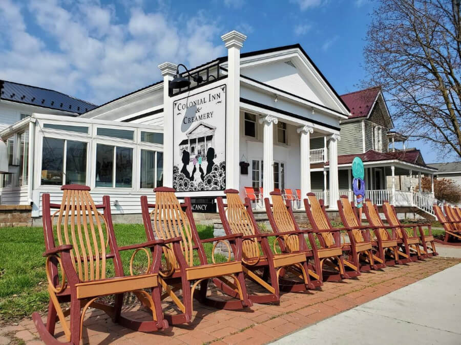 Exterior photo of a white building with deck chairs lined up outside