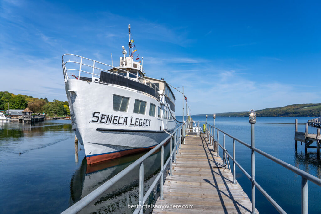 White cruise boat with Seneca Legacy written on side sat on blue lake with pontoon