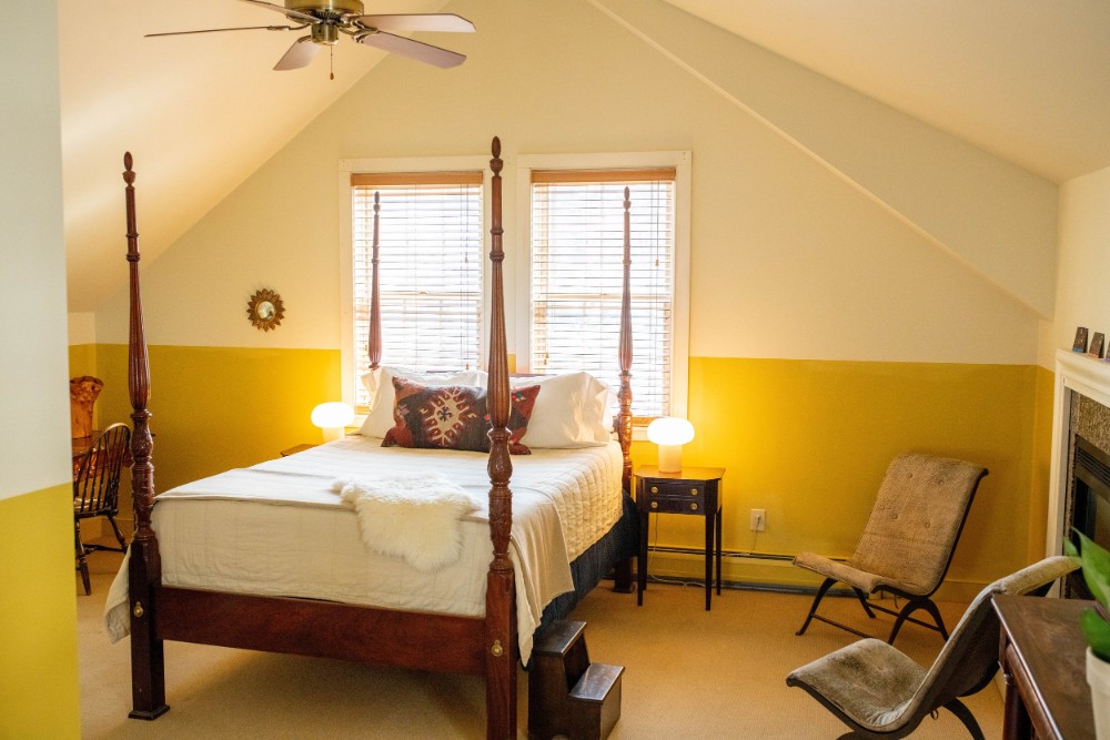Guest bedroom with four poster bed and yellow colors