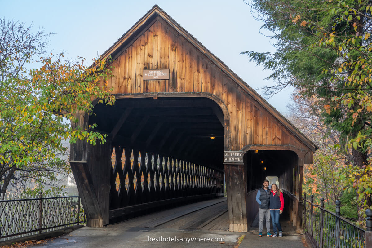 Couple standing in the walkway of a covered bridge