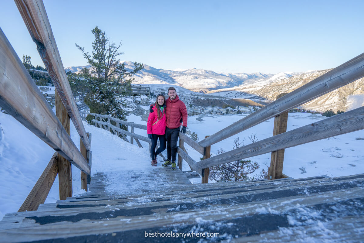 Couple in winter clothing stood on a snowy trail in Wyoming