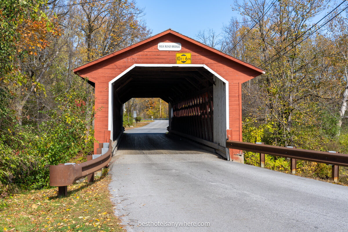 Red covered bridge in rural Vermont on a sunny day