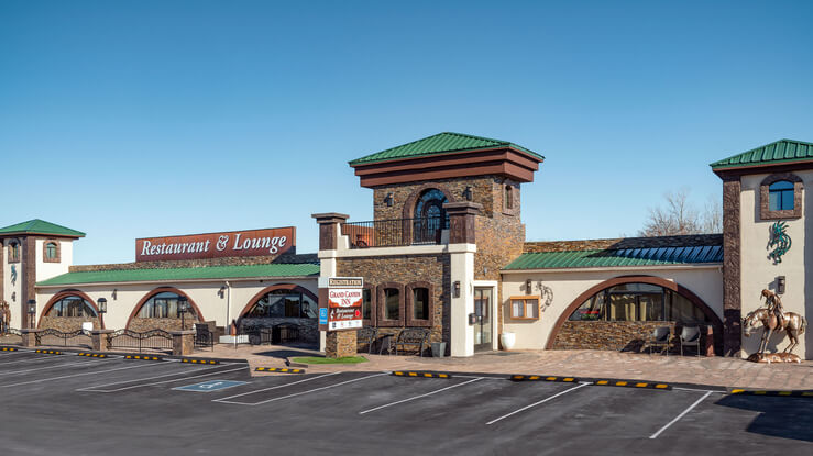 Exterior photo of a long one building with hotel and lounge in Grand Canyon Junction on a clear day