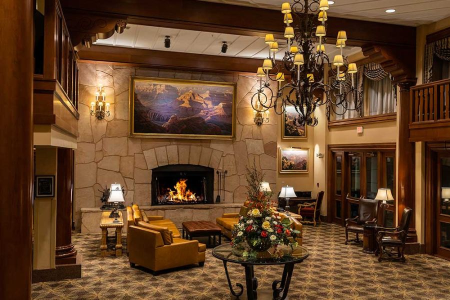 The lobby of Grand Canyon Railway Hotel in Williams AZ featuring an old west theme with fireplace and seating under wood paneled beams