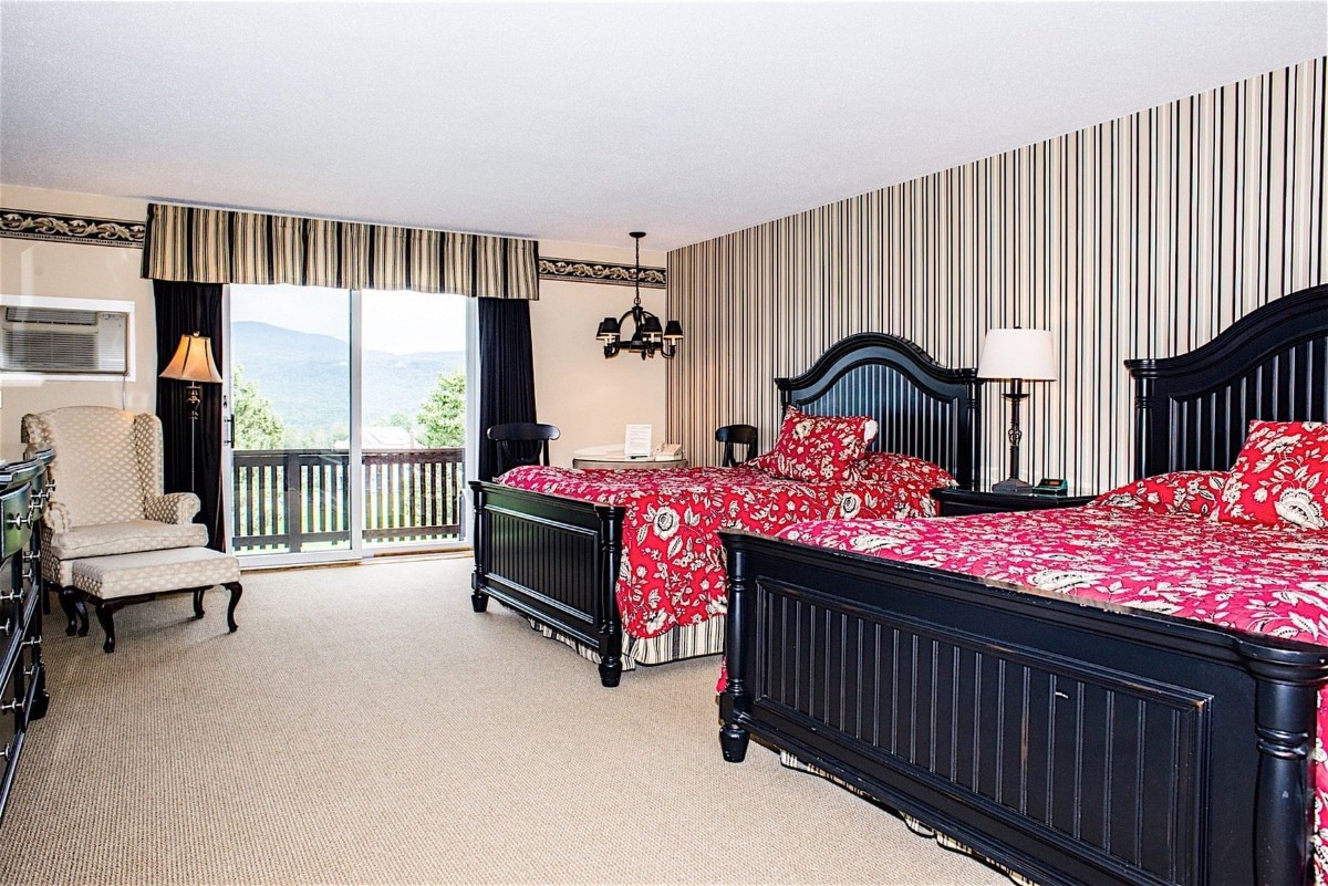 Inside a guest bedroom with two large beds and a light carpet
