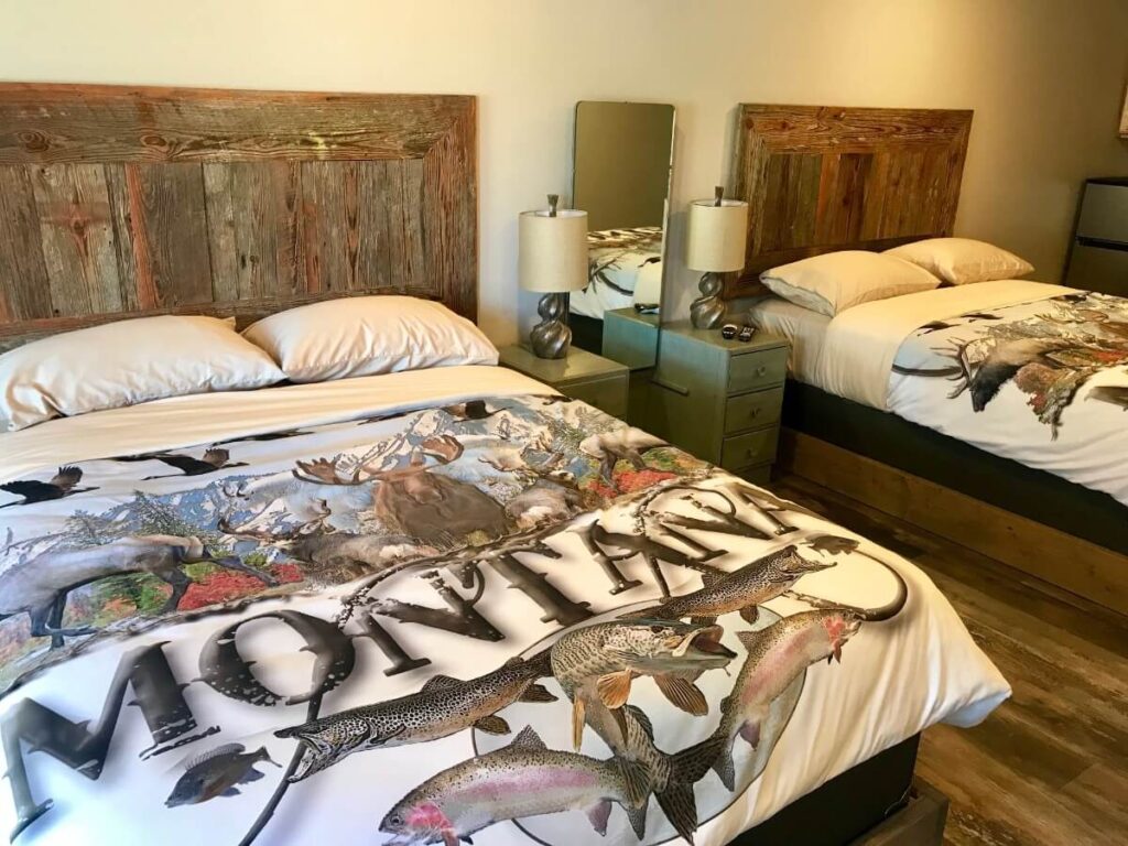Inside a guest bedroom at a lodge in Gardiner Montana with artistic bed sheets