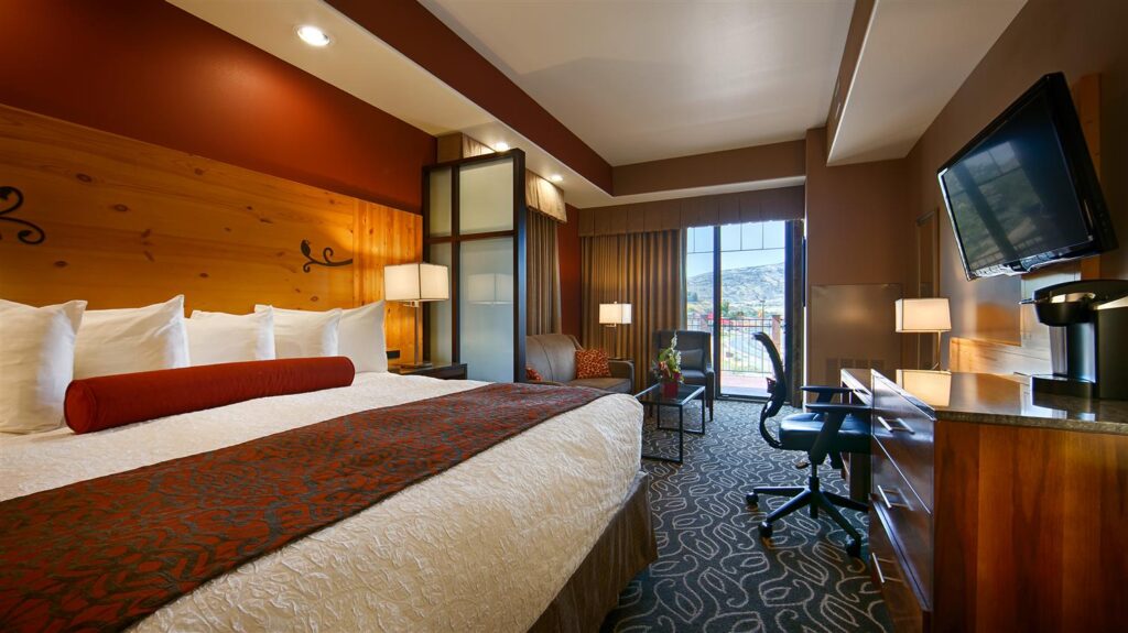 Inside a plush guest bedroom with king size bed tv desk and chair