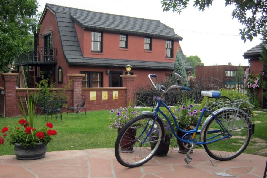 Exterior photo of an inn in Cody WY with bicycle and garden