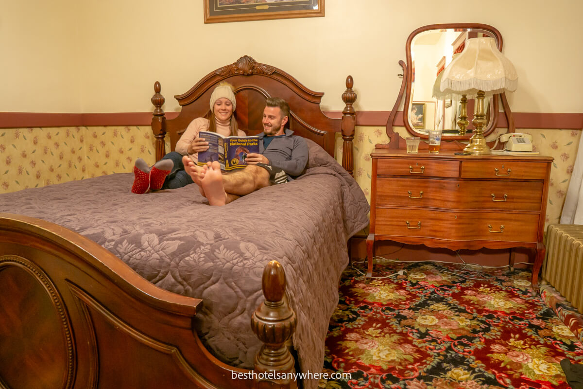Couple laying on a bed at a historic hotel in Cody Wyoming