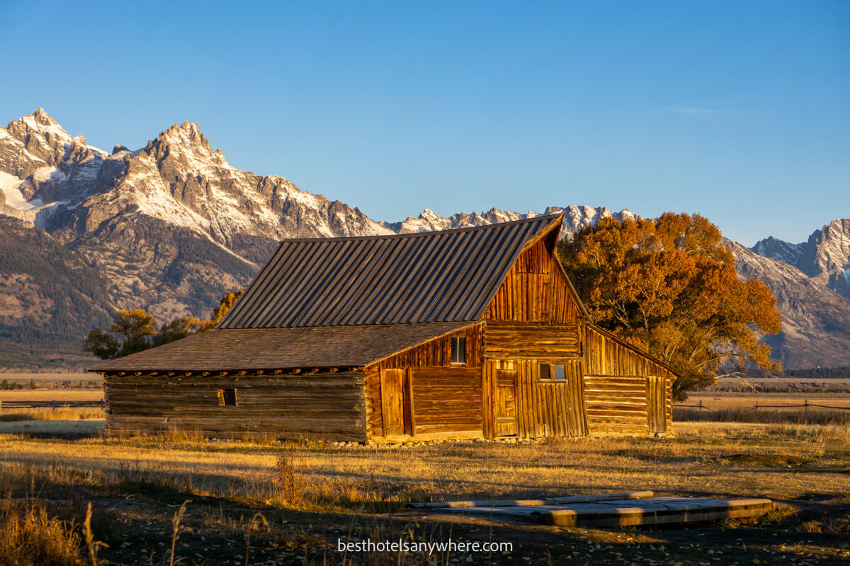 Wooden barn on Mormon Row at sunrise with plains and mountains behind