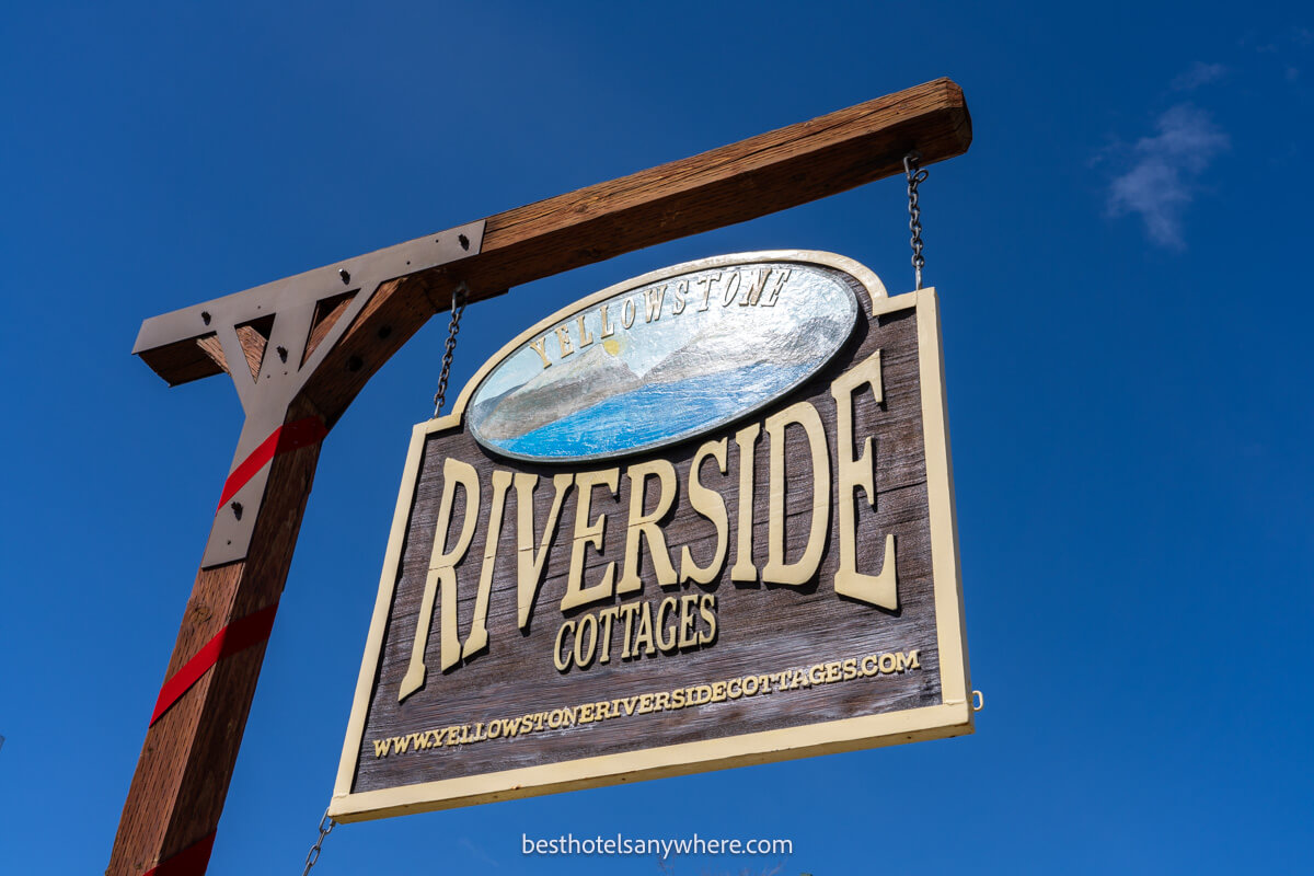 Sign for Yellowstone Riverside Cottages one of the best hotels in Gardiner MT with deep blue sky behind the sign